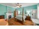 Bedroom with hardwood floors, a white fireplace, a ceiling fan, and light turquoise painted walls at 165 Mimosa Ter, Wadesboro, NC 28170