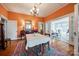 Inviting dining room with hardwood floors, chandelier lighting, an area rug, and sliding glass doors to a sun room at 165 Mimosa Ter, Wadesboro, NC 28170