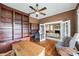 Spacious home office featuring custom built-ins, ceiling fan, hardwood floors, and French doors to the living room at 165 Mimosa Ter, Wadesboro, NC 28170