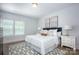Bright bedroom featuring a comfortable bed with white linens, two side tables and decor at 19751 Feriba Pl, Cornelius, NC 28031