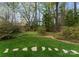 Lush backyard featuring a grassy lawn, stone steps, and mature trees, providing a serene and private outdoor space at 2015 Pellyn Wood Dr, Charlotte, NC 28226