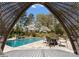 A backyard with an in-ground pool and patio dining set, viewed through a lattice gazebo at 2015 Pellyn Wood Dr, Charlotte, NC 28226