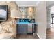 Stylish home bar with glass shelves, accent lighting, and stone accents at 2015 Pellyn Wood Dr, Charlotte, NC 28226