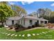 Well-maintained white home featuring a neatly landscaped yard, stone walkway, and private backyard at 2015 Pellyn Wood Dr, Charlotte, NC 28226