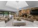 Elegant living room with a stone fireplace, wood storage, and view of outdoor pool at 2015 Pellyn Wood Dr, Charlotte, NC 28226