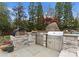 Stunning outdoor kitchen featuring a pizza oven, grill, and stainless steel cabinetry, perfect for al fresco entertaining at 2015 Pellyn Wood Dr, Charlotte, NC 28226