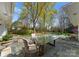 Charming outdoor patio with a glass-top table and comfortable seating, overlooking a beautifully landscaped backyard at 2015 Pellyn Wood Dr, Charlotte, NC 28226