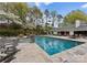A luxurious swimming pool featuring a spa, stone accents, and elegant patio furniture for outdoor relaxation at 2015 Pellyn Wood Dr, Charlotte, NC 28226
