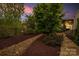 Lush backyard featuring a rock pathway, mulch landscaping, manicured trees, and outdoor seating area perfect for entertaining at 2035 Palace Way, Indian Land, SC 29707