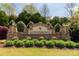 Stone Queensbridge community sign surrounded by manicured landscaping, lush green shrubs and flowers at the entrance at 2035 Palace Way, Indian Land, SC 29707