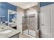 Bathroom featuring a tiled walk-in shower with bench and glass door, alongside a granite countertop sink at 2035 Palace Way, Indian Land, SC 29707