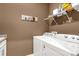 Functional laundry room with white washer and dryer and overhead storage shelving at 2035 Palace Way, Indian Land, SC 29707