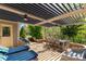 Inviting outdoor patio with a louvered cover, featuring comfortable seating and dining area amidst lush greenery at 2035 Palace Way, Indian Land, SC 29707