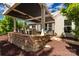 Lush patio featuring a stone retaining wall, louvered roof, manicured landscaping and outdoor seating at 2035 Palace Way, Indian Land, SC 29707
