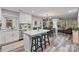 A modern kitchen offering an island with stool seating and an open-concept design flowing into the living room at 2117 Camp Greene St, Charlotte, NC 28208