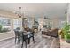Spacious living room featuring modern light fixture, stone fireplace, open to kitchen and dining space at 2117 Camp Greene St, Charlotte, NC 28208