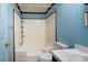 Bathroom featuring a shower and bath, toilet, and vanity sink with blue walls at 216 Sylvan Rd, China Grove, NC 28023