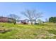 Exterior view of home with lawn, mature trees, deck, and blue sky background at 216 Sylvan Rd, China Grove, NC 28023