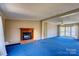 Living room showcasing a fireplace, ceiling fan, neutral walls, blue carpeting at 216 Sylvan Rd, China Grove, NC 28023