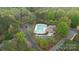 Aerial view of a well-maintained community pool and clubhouse with ample parking, set amidst lush greenery at 2228 Metcalf Dr, Sherrills Ford, NC 28673