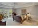 Relaxing main bedroom featuring large windows, a tray ceiling, and a seating area at 2228 Metcalf Dr, Sherrills Ford, NC 28673