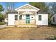 Charming white home featuring a covered front porch with a bright blue front door and a well-manicured lawn at 243 Barber St, Rock Hill, SC 29730