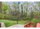 View of the backyard from the deck, showing the wooded area and landscaping at 2714 Dogwood Cir, Charlotte, NC 28208