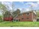 The backyard has a lawn, brick house and a red deck at 2714 Dogwood Cir, Charlotte, NC 28208