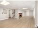 Spacious basement features a cozy brick fireplace, staircase, and light wood laminate flooring at 2714 Dogwood Cir, Charlotte, NC 28208
