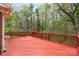 Spacious red deck with wood railings overlooking a lush, tree-filled backyard at 2714 Dogwood Cir, Charlotte, NC 28208