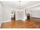 Open dining area with hardwood floors and a modern chandelier, adjacent to the living room and kitchen at 2714 Dogwood Cir, Charlotte, NC 28208