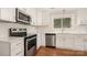 Updated kitchen showcasing stainless steel appliances, white cabinets, and bright countertops at 2714 Dogwood Cir, Charlotte, NC 28208