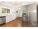 Modern kitchen with stainless steel refrigerator and white cabinets, seamlessly connecting to dining area at 2714 Dogwood Cir, Charlotte, NC 28208