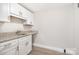 Laundry room featuring white cabinets, a granite countertop, and a sink at 2714 Dogwood Cir, Charlotte, NC 28208
