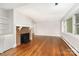 Bright living room boasts hardwood floors, a brick fireplace, and large windows for ample light at 2714 Dogwood Cir, Charlotte, NC 28208