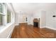 Bright living room boasts hardwood floors, a brick fireplace, and large windows for ample light at 2714 Dogwood Cir, Charlotte, NC 28208