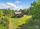 A picturesque backyard with a brick home, wooden deck, and lush landscaping for outdoor enjoyment at 2805 Sadler Rd, Alexis, NC 28006