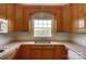 Close-up of a kitchen with oak cabinets, white countertops and a window at 2805 Sadler Rd, Alexis, NC 28006