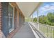 Covered front porch with white railings and a view of the green yard at 2805 Sadler Rd, Alexis, NC 28006