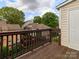 View from balcony overlooking courtyard, featuring wooden railing and door to the building at 3210 Selwyn Farms Ln # 7, Charlotte, NC 28209