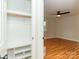Bedroom featuring wooden floors, a ceiling fan and an adjacent closet with built-in shelving at 3210 Selwyn Farms Ln # 7, Charlotte, NC 28209