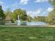 Picturesque community pond with fountain and lush green surroundings on a sunny day at 3210 Selwyn Farms Ln # 7, Charlotte, NC 28209