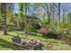 Backyard with a cozy fire pit area, surrounded by seating and lush greenery, ideal for gatherings at 3846 22Nd Ne St, Hickory, NC 28601