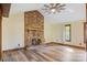 Bright living room featuring a brick fireplace, wood floors, vaulted ceiling, and large windows at 3846 22Nd Ne St, Hickory, NC 28601