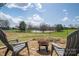 Scenic backyard featuring a fire pit, mature trees, and a serene pond at 396 Tower Rd, Vale, NC 28168
