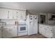 A well-lit kitchen features white appliances, white cabinets, and marble countertops at 396 Tower Rd, Vale, NC 28168