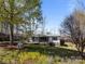 Charming single-story home featuring a screened porch, wheelchair ramp, and carport surrounded by trees at 404 Forest Winds Dr, Salisbury, NC 28144