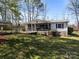 Charming single-story home featuring a screened porch, wheelchair ramp, and carport surrounded by trees at 404 Forest Winds Dr, Salisbury, NC 28144