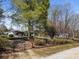 Fenced yard featuring the house with a screen porch, wheelchair ramp, a carport, and mature trees at 404 Forest Winds Dr, Salisbury, NC 28144