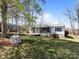 Charming single-story home featuring a screened porch, wheelchair ramp, and carport surrounded by trees at 404 Forest Winds Dr, Salisbury, NC 28144